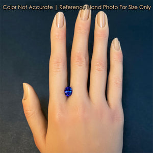 mostly blue oval tanzanite gemstone on hand