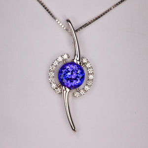 round brilliant tanzanite rare gemstone pendant with diamond accents in modern white gold design