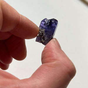 raw tanzanite in hand