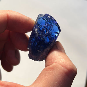 deep color tanzanite crystal in hand 