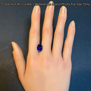 mostly blue oval tanzanite gemstone on hand