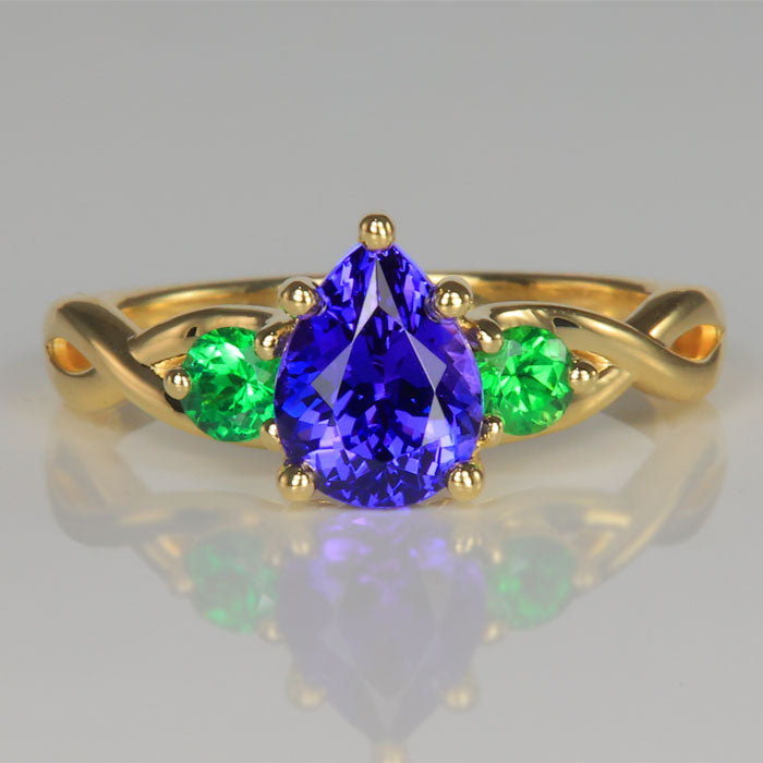 pear shape brilliant cut tanzanite gemstone ring in yellow gold with tsavorite garnet accents 