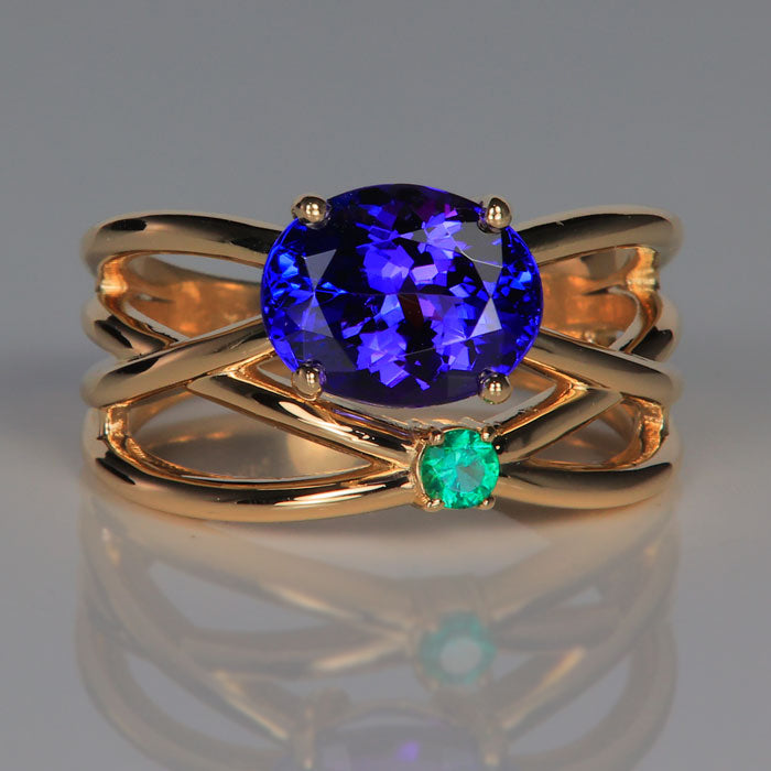 oval  cut tanzanite with emerald accent ring in yellow gold